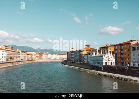 Wunderschöner Blick auf die Gebäude entlang des Arno Flusses in Pisa, Italien. Eine Brücke führt über den Fluss und Häuser auf beiden Seiten blicken auf das Wasser Stockfoto