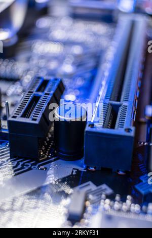 Motherboard-Sockel, Anschlüsse und Mikrochips schließen sich bei blauem Licht am Desktop-PC an. Komponenten des Chipsatzes der Computerhardware. Elektronik der technischen Industrie b Stockfoto