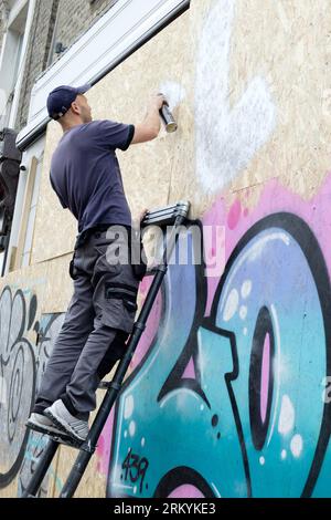 Graffiti-Aritisten Notting Hill Carnival 2023, London, UK. Künstler kommen aus ganz Großbritannien, um am Tag vor Beginn des Karnevals die Hordings zu malen. Quelle: Mary-Lu Bakker/Alamy Live News Stockfoto