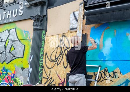 Graffiti-Aritisten Notting Hill Carnival 2023, London, UK. Künstler kommen aus ganz Großbritannien, um am Tag vor Beginn des Karnevals die Hordings zu malen. Quelle: Mary-Lu Bakker/Alamy Live News Stockfoto