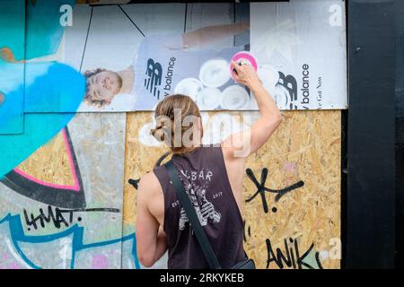 Graffiti-Aritisten Notting Hill Carnival 2023, London, UK. Künstler kommen aus ganz Großbritannien, um am Tag vor Beginn des Karnevals die Hordings zu malen. Quelle: Mary-Lu Bakker/Alamy Live News Stockfoto