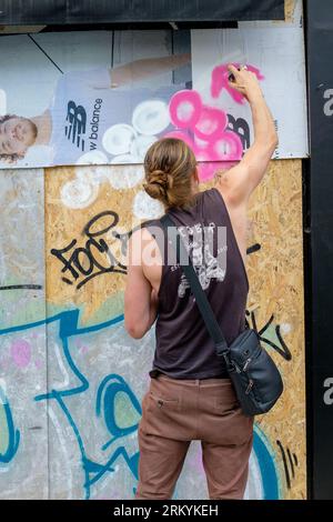 Graffiti-Aritisten Notting Hill Carnival 2023, London, UK. Künstler kommen aus ganz Großbritannien, um am Tag vor Beginn des Karnevals die Hordings zu malen. Quelle: Mary-Lu Bakker/Alamy Live News Stockfoto