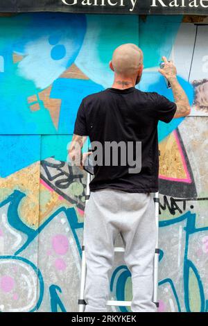 Graffiti-Aritisten Notting Hill Carnival 2023, London, UK. Künstler kommen aus ganz Großbritannien, um am Tag vor Beginn des Karnevals die Hordings zu malen. Quelle: Mary-Lu Bakker/Alamy Live News Stockfoto