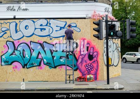 Graffiti-Aritisten Notting Hill Carnival 2023, London, UK. Künstler kommen aus ganz Großbritannien, um am Tag vor Beginn des Karnevals die Hordings zu malen. Quelle: Mary-Lu Bakker/Alamy Live News Stockfoto