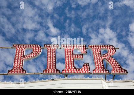 Neonschild Brighton Pier mit hellblauem Himmel Stockfoto