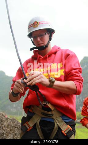 Bildnummer: 59287014  Datum: 01.03.2013  Copyright: imago/Xinhua (130301) -- KUNMING, March 1, 2013 (Xinhua) -- Lydia, a fire-control volunteer from the Netherlands, puts on equipment before a rescue training in Yangshuo County, a tourist resort in southwest China s Guangxi Zhuang Autonomous Region, March 1, 2013. Lydia and Sarah from the United States are members of a volunteer firefighter team of the West Street in Yangshuo, which is nicknamed as the foreigners street, or the Global Village as over 140 foreigners from more than 20 countris and regions are long stayers on this street. The Wes Stock Photo