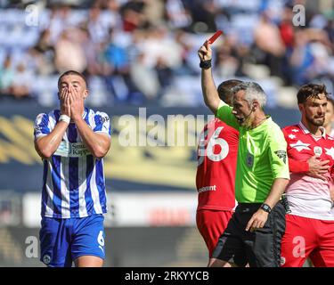 Wigan, UK. 26th Aug, 2023. Referee Seb Stockbridge gives Charlie Hughes #6 of Wigan Athletic a red card during the Sky Bet League 1 match Wigan Athletic vs Barnsley at DW Stadium, Wigan, United Kingdom, 26th August 2023 (Photo by Mark Cosgrove/News Images) in Wigan, United Kingdom on 8/26/2023. (Photo by Mark Cosgrove/News Images/Sipa USA) Credit: Sipa USA/Alamy Live News Stock Photo