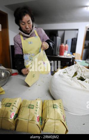 Bildnummer: 59439356 Datum: 25.03.2013 Copyright: imago/Xinhua Ein Teehändler packt Longjing-Tee mit ökonomischen Wraps in Longjing Village, Hangzhou, Hauptstadt der ostchinesischen Provinz Zhejiang, 25. März 2013. Wirtschaftliche Verpackungsmaterialien gewinnen bei den Teehändlern in Hangzhou an Beliebtheit. Als Kombination aus Reispapier und Kraftpapier weist das neue Paket bessere Luft- und feuchtigkeitsbeständige Eigenschaften auf, die für die Teekonservierung von entscheidender Bedeutung sind, kostet es jedoch deutlich weniger als hyperluxuriöse Mahagoni-Boxen oder feine porzellanbehälter, die einst den Markt dominierten. (Xinhua/Ju Huanzong) (lmm) CHINA-ZHEJIANG-HANGZHOU-LONGJING T Stockfoto