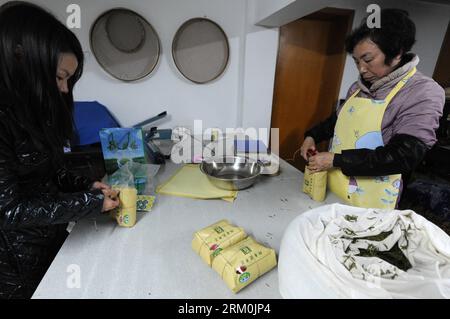 Bildnummer: 59439354  Datum: 25.03.2013  Copyright: imago/Xinhua Two tea traders pack Longjing Tea using economical wraps in Longjing Village, Hangzhou, capital of east China s Zhejiang Province, March 25, 2013. Economical packaging materials are gaining popularity among Hangzhou s tea traders. A combo of rice paper and kraft paper, the new package has better air- and moisture-proof characteristics vital to tea preservation, yet costs far less than hyper-luxurious mahogany boxes or fine china containers that once dominated the market. (Xinhua/Ju Huanzong) (lmm) CHINA-ZHEJIANG-HANGZHOU-LONGJING Stock Photo