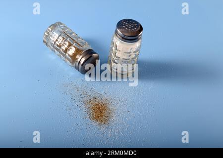Salz- und Pfefferstreuer von oben gesehen. Salz- und Pfefferkörner auf der Oberfläche. Stockfoto