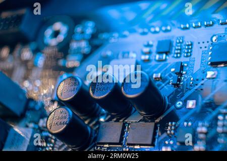 Kiew, Ukraine - 05. Januar 2022: Motherboard mit Mikrochips und Widerständen, Desktop-PC-Nahaufnahme in blauem Licht. Komponenten des Chipsatzes der Computerhardware b Stockfoto