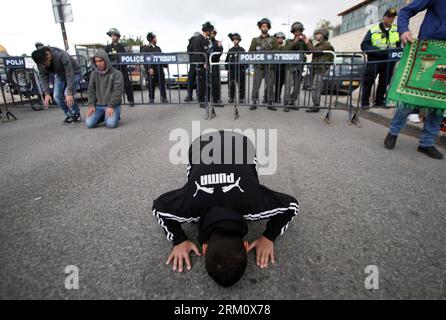 Bildnummer: 59477599  Datum: 05.04.2013  Copyright: imago/Xinhua (130405) -- JERUSALEM, April 5, 2013(Xinhua) -- Israeli border police officers stand guard as Palestinians pray on a street in the East Jerusalem neighbourhood of Ras al-Amud, on April 5, 2013. Israeli forces sealed off the West Bank and massed riot squads around Jerusalem s Old City. Israel said Thursday that Hamas was responsible for shelling fire from Gaza into southern Israel, but do not see another military operation soon. (Xinhua/Muammar Awad) (zf) MIDEAST-JERUSALEM-PRAYER PUBLICATIONxNOTxINxCHN Gesellschaft xas x2x 2013 qu Stock Photo