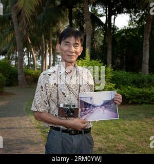 Bildnummer: 59483880 Datum: 08.04.2013 Copyright: imago/Xinhua BOAO, 2013 - Lin Juehao, 66, ein pensionierter Lehrer der Boao Middle School, posiert mit einem Dateifoto in Boao, einer Küstenstadt in der südchinesischen Provinz Hainan, 5. April 2013. Das 2000 von Lin aufgenommene Foto zeigt eine Straße in der Stadt. Heute wurde derselbe Ort in einen Hotelgarten verwandelt. LIN sagte, Boao sei mit dem Boao Forum for Asia (BFA) schöner geworden. Das Forum, das dem Weltwirtschaftsforum in Davos nachempfunden ist, hat nun sein zwölftes Jahr. Die BFA-Jahrestagung 2013 findet von Stockfoto