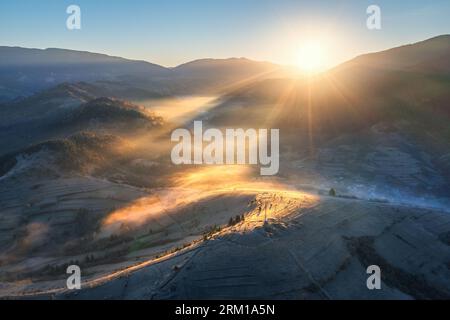 Luftaufnahme von Bergen und Hügeln in niedrigen Wolken bei Sonnenaufgang Stockfoto