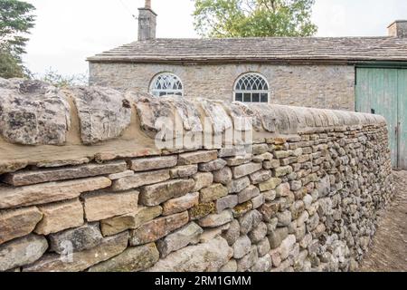 Neue Mauer und Tor, die auf hohem Standard gebaut wurden, am ehemaligen alten Schulgebäude, das heute vielleicht als Garagge genutzt wird, in Long Preston North Yorkshire Stockfoto