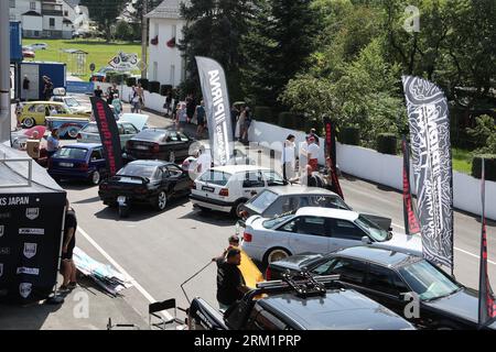 Schleiz, Deutschland. 26. August 2023. Bei der Eröffnung der Motorwelt „Schleizer Dreieck“ laufen die Besucher durch die Ausstellungsfläche. Der Schleizer Dreieck ist Deutschlands älteste Strassenbahn und auch heute noch Austragungsort von Motorsportrennen. Das Museum ist der hundertjährigen Geschichte der Rennstrecke gewidmet. Quelle: Bodo Schackow/dpa/Alamy Live News Stockfoto