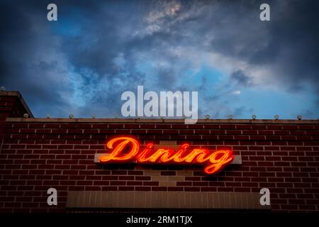 Der Abendhimmel hinter einem Diner-Schild auf einem Gebäude in Ludington, Michigan. Stockfoto