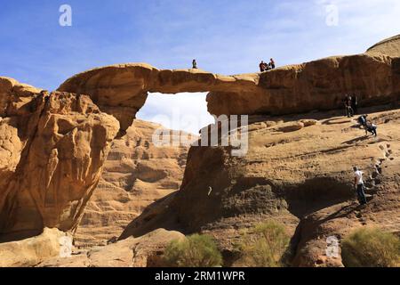 Touristen an der Burdah-Felsbrücke, Wadi Rum, UNESCO-Weltkulturerbe, Jordanien, Naher Osten Stockfoto