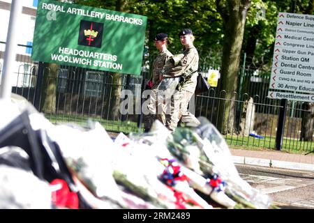 Bildnummer: 59686721 Datum: 23.05.2013 Copyright: imago/Xinhua (130523) -- LONDON, 23. Mai 2013 (Xinhua) -- Blumen werden am Eingang der Royal Artillery Barracks gelegt, als zwei Soldaten in Woolwich im Südosten Londons am 23. Mai 2013 vorbeiziehen. Ein Soldat wurde am Mittwochnachmittag von zwei Angreifern mit Messern, darunter einem Fleischspalter in der Nähe der Royal Artillery Barracks in Woolwich, zu Tode gehackt. (Xinhua/Bimal Gautam) UK-LONDON-GEDENKEN PUBLICATIONxNOTxINxCHN Gesellschaft Politik Terror Anschlag Terroranschlag Mord Soldat Trauer xcb x0x 2013 quer premiumd 59686721 Datum 23 Stockfoto