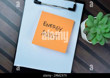 Konzept der Energieprüfung Schreiben Sie auf Haftnotizen, die auf einem Holztisch isoliert sind. Stockfoto