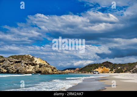 Strand und felsige Küste unter einem Himmel mit dunklen Wolken. Auto am Strand. Nanarup Beach in der Nähe von Albany, Western Australia. Stockfoto