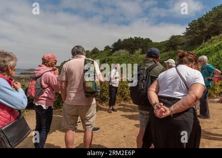 Herm Island, Kanalinseln, Vereinigtes Königreich. Juni 2023. Eine Gruppe von Touristen hört ihren Reiseleiter während eines Spaziergangs rund um die Insel Herm. Stockfoto