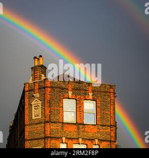 London, Großbritannien. 26. August 2023. Nach einem Tag mit manchmal wunderschönem Sonnenschein und mehreren sehr schweren Duschen in London kann heute Abend ein lebhaft farbenfroher Doppelregenbogen über Lewisham im Südosten Londons gesehen werden. Die Prognosen deuten auf ein weiteres gemischtes Wetter in den kommenden Tagen hin. Quelle: Imageplotter/Alamy Live News Stockfoto
