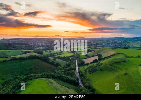 Bridport, Dorset, Großbritannien. 26. August 2023. Wetter in Großbritannien. Die Wolken leuchten orange bei Sonnenuntergang über den Feldern in der Nähe von Bridport in Dorset am Ende eines Tages mit Sonnenschein und starkem Gewitter. Bildnachweis: Graham Hunt/Alamy Live News Stockfoto