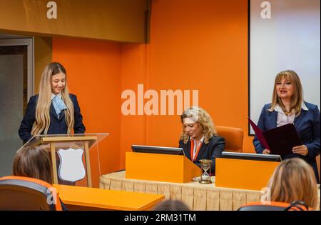 Gruppe von Studenten und Professoren, die sich darauf vorbereiten, von ihren Schülern ein Projekt präsentieren zu hören Stockfoto