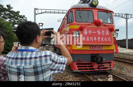 Bildnummer: 59930878  Datum: 02.07.2013  Copyright: imago/Xinhua (130702) -- HAIKOU, July 2, 2013 (Xinhua) -- Passengers take photos of the locomotive of the first direct train from Haikou to Harbin at Haikou Railway Station in Haikou, capital of south China s Hainan Province, July 2, 2013. The train K1122/3 from south China s Haikou to northeast China s Heilongjiang left Haikou Tuesday, a day later than its original departure date due to the tropical storm Rumbia. The train which travels 4,458 kilometers for 65 hours has connected China s southernmost capital city Haikou of Hainan Province wi Stock Photo