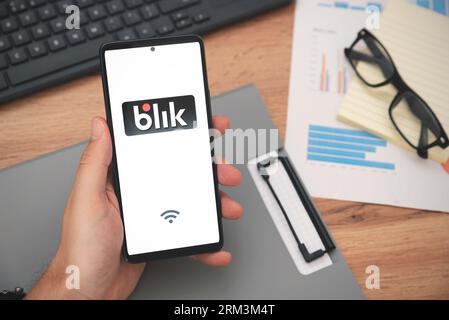 Wroclaw, Polen – 24. August 2023: Mann mit Smartphone mit Blik-Logo, kontaktlose Zahlung. Blik ist die beliebteste Schnellzahlungsmethode Polens Stockfoto