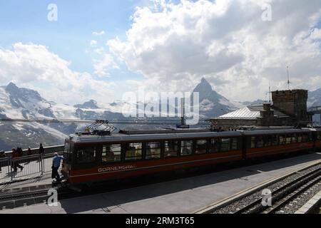 Bildnummer: 60318732  Datum: 04.08.2013  Copyright: imago/Xinhua ZERMATT, Aug., 2013 - A Gornergrat cogwheel train comes through Matterhorn in Zermatt, Switzerland, Aug. 4, 2013. The Gornergrat mountain climbing railway is the first open-air cogwheel railway which was built in 1898. From Zermatt station, the tourists can climb the mountain with trains every 24 minutes-over impressive bridges, through galleries and tunnels, passing rocky gorges and mountain lakes. At the destination, the viewing platform at 3,089 meters above the sea level in Gornergrat station, the tourists can appreciate 29 p Stock Photo