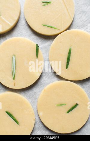 Draufsicht auf ausgeschnittenen rohen Rosmarin-Zucker-Keksenteig, Rosmarin-Keksenteig, der gerade gebacken wird, Prozess der Herstellung von Rosmarin-Zucker-Keksen Stockfoto