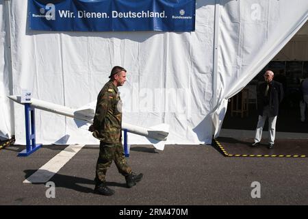 Bildnummer: 60388516  Datum: 24.08.2013  Copyright: imago/Xinhua (130824) -- BERLIN, Aug. 24, 2013 (Xinhua) -- A military officer walks at Germany s Ministry of Defence during the open day of German government in Berlin, Germany, on Aug. 24, 2013. The Banner reads we serve Germany . German government opened its door to the public this weekend, inviting citizens to visit several ministries and government offices in the German capital of Berlin. (Xinhua/Zhang Fan) (jl) GERMANY-BERLIN-GOVERNMENT-OPEN DAY PUBLICATIONxNOTxINxCHN Politik Verteidigungsministerium Tag der offenen Tür premiumd x0x xsk Stock Photo