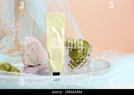 Tube Creme, Oliven und Steine in Glasschale, Platz für Text Stockfoto