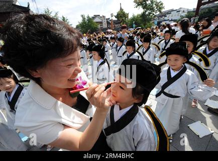 Bildnummer: 60418635  Datum: 01.09.2013  Copyright: imago/Xinhua (130901) -- NANJING, Sept. 1, 2013 (Xinhua) -- A teacher gives first-graders a red dot on their foreheads (which is called opening the wisdom eye) during the first writing ceremony at Fuzimiao, or the Confucius Temple, in Nanjing, capital of east China s Jiangsu Province, Sept. 1, 2013. In total 370 first-graders of Fuzimiao elementary school in Nanjing participated in the first writing ceremony Sunday. The ceremony is a traditional education activity for children in China. (Xinhua/Sun Can)(wjq) CHINA-JIANGSU-NANJING-FIRST WRITIN Stock Photo