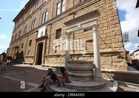 Bildnummer: 60528705 Datum: 25.09.2013 Copyright: imago/Xinhua zwei Touristen sitzen neben dem Hundebrunnen am Piccolomini-Palast in Pienza, Italien, 25. September 2013. In dieser toskanischen Stadt wurden Stadtplanungskonzepte der Renaissance erstmals umgesetzt, nachdem Papst Pius II. 1459 beschloss, das Aussehen seines Geburtsortes zu verändern. Er wählte den Architekten Bernardo Rossellino, der die Prinzipien seines Mentors Leon Battista Alberti anwandte. Diese neue Vision des urbanen Raums wurde auf dem herrlichen Platz, der als Piazza Pio II bekannt ist, und den Gebäuden um ihn herum verwirklicht: Dem Piccolomini-Palast, dem Stockfoto