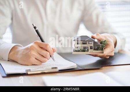 Asiatischer Geschäftsmann, der einen Immobilienvertrag abschließt Stockfoto