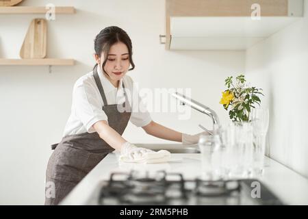 Asiatische Frau wischt die Küche ab Stockfoto
