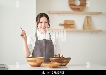 Asiatische Frau, die in die Küche zeigt Stockfoto