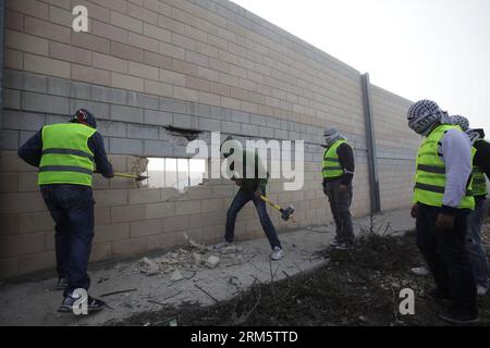 Bildnummer: 60720053  Datum: 15.11.2013  Copyright: imago/Xinhua (131115) -- JERUSALEM, Nov. 15, 2013 (Xinhua) -- Palestinians begin to break a hole on the controversial Israeli separation wall next to a main highway leading to Jerusalem, outside the West Bank village of Bir Nabala, on Nov. 15, 2013. The action was carried out just at sunrise and the Border police quickly discovered the breach in the controversial wall, and began work to fill the hole. (Xinhua/Muammar Awad) MIDEAST-BIR NABALA-ISRAELI SEPARATION WALL-HOLE BREAKING PUBLICATIONxNOTxINxCHN Politik Grenze Mauer Steinmauer zerstören Stock Photo