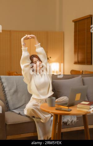 Nachtleben-Konzept, Junge Frau, die sich nach der Arbeit im späten Winter zur Entspannung ausdehnt. Stockfoto