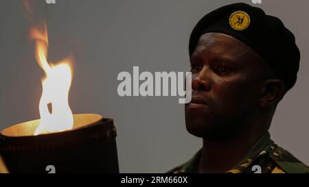 Bildnummer: 60815281  Datum: 10.12.2013  Copyright: imago/Xinhua     (131210) -- JOHANNESBURG, Dec. 10, 2013 -- A South African soldier watches the flame of the torch before entering the field during the memorial service for Nelson Mandela in Johannesburg, South Africa, on Dec. 10, 2013. Memorial service for former South African President Nelson Mandela started in Johannesburg on Tuesday as tens of thousands of mourners and more than 90 world leaders gather in rain to remember Mandela at memorial. (Xinhua/Zhang Chen) SOUTH AFRICA-JOHANNESBURG-NELSON MANDELA-MEMORIAL SERVICE PUBLICATIONxNOTxINx Stock Photo