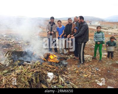 Bildnummer: 60817241  Datum: 11.12.2013  Copyright: imago/Xinhua     (131211) -- BEIRUT, Dec. 11, 2013 (Xinhua) -- Syrian refugees make a fire to get warm in a refugee camp in southern Lebanon, Dec. 11, 2013. As the winter is coming, how to endure the cold temperature becomes a problem for Syrian refugees in Lebanon.(Xinhua) (dzl) LEBANON-SYRIAN REFUGEE-WINTER PUBLICATIONxNOTxINxCHN Gesellschaft Flüchtlinge Kinder xsp x0x 2013 quer Stock Photo