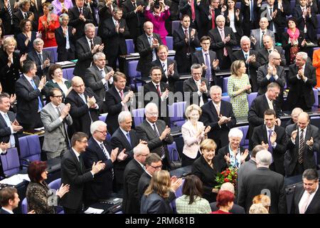 (131217) -- BERLIN, 17. Dezember 2013 (Xinhua) -- Bundeskanzlerin Angela Merkel (mit Blumen) wird von den parlamentsmitgliedern Hermann Gröhe, Alexander Dobrindt, Peter Altmaier, Rainer Pofalla, Hans-Peter Friederich, Thomas de Maiziere, Kristina Schröder, Peter Tauber, Peter Ramsauer, Ursula von der Leyen während der Sitzung des bundestages am 17. Dezember 2013 in Berlin. Angela Merkel wurde am Dienstag in einer Abstimmung im Unterhaus des parlaments für eine dritte Amtszeit wiedergewählt, und ihre Koalitionsregierung wird vereidigt werden, um die Großen Europas zu regieren Stockfoto