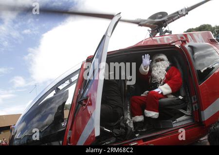 (131219) -- GUATEMALA CITY, 19. Dezember 2013 (Xinhua) -- Ein Mann, der sich als Santa Claus verkleidet hat, weht bei der Ankunft mit dem Hubschrauber im San Juan de Dios General Hospital, in Guatemala City, Hauptstadt von Guatemala, am 18. Dezember 2013. Der Weihnachtsmann besuchte das Kinderkrankenhaus, um im Rahmen der Weihnachtsfeierlichkeiten Geschenke zu überreichen. (Xinhua/Luis Echeverria) GUATEMALA-GUATEMALA CITY-SOCIETY-CHRISTMAS PUBLICATIONxNOTxINxCHN Guatemala City DEC 19 2013 XINHUA ein Mann verkleidet als Santa Claus Wellen BEI Ankunft mit dem Hubschrauber IM San Juan de Dios General Hospital in Guatemala City Hauptstadt von Guatemala AM DEC 18 Stockfoto