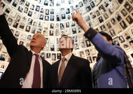 (131219) -- JERUSALEM, Dec. 19, 2013 (Xinhua) -- Visiting Chinese Foreign Minister Wang Yi (C) looks at pictures of Jews killed in the Holocaust during a visit to the Hall of Names at Yad Vashem Holocaust Memorial Museum in Jerusalem, on Dec. 19, 2013. (Xinhua/Muammar Awad) MIDEAST-JERUSALEM-CHINA-FM-WANG YI-YAD VASHEM HOLOCAUST MEMORIAL MUSEUM-VISIT PUBLICATIONxNOTxINxCHN   Jerusalem DEC 19 2013 XINHUA Visiting Chinese Foreign Ministers Wang Yi C Looks AT Pictures of Jews KILLED in The Holocaust during a Visit to The Hall of Names AT Yad Vashem Holocaust Memorial Museum in Jerusalem ON DEC 19 Stock Photo