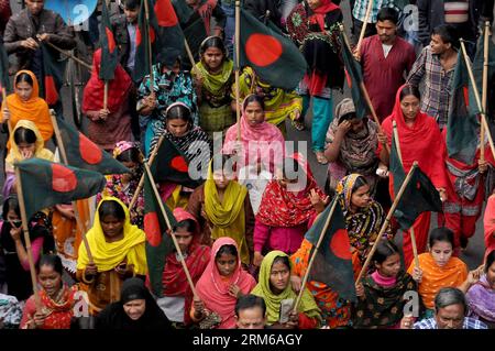 (131227) -- DHAKA, 27. Dezember 2013 (Xinhua) -- Bekleidungsarbeiter nehmen an einer Protestkundgebung mit bangladeschischen Flaggen Teil, bei der die Inhaftierung des Eigentümers der Bekleidungsfabrik Tazreen Fashion Limited in Dhaka, Bangladesch, 27. Dezember 2013 gefordert wird. Am 24. November 2012 starben in der Bekleidungsfabrik Tazreen Fashion Limited in Ashulia am Stadtrand der Hauptstadt Dhaka mindestens 112 Arbeiter bei einem Brand. (Xinhua/Shariful Islam) BANGLADESCH-DHAKA-PROTEST PUBLICATIONxNOTxINxCHN Dhaka DEC 27 2013 XINHUA Bekleidungsarbeiter nehmen an einer Protestkundgebung mit Bangladeshi Flags Teil, bei der die Inhaftierung des Eigentümers der Fashion Limi gefordert wird Stockfoto