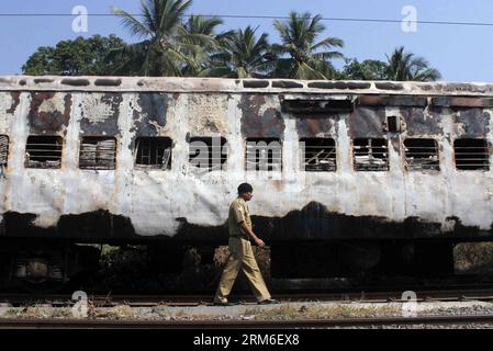 (140109) -- THANE, 8. Januar 2014 (Xinhua) -- Eine Person kommt an den verbrannten Reisebussen des Mumbai-Dehradun Express vorbei, die am 8. Januar 2014 in Dahanu im Bezirk Thane in Maharashtra, Indien, in Brand gerieten. Neun Menschen, darunter eine Frau, wurden bei einem Großbrand, der auf dem Schnellzug im westindischen Bundesstaat Maharashtra in den frühen Morgenstunden des Mittwochs ausbrach, zu Tode gebrannt, sagte ein leitender Polizeibeamter. (Xinhua/Stringer) INDIA-MAHARASHTRA-EXPRESS TRAIN-FIRE PUBLICATIONxNOTxINxCHN 8. Januar 2014 XINHUA A Person Pass durch die verbrannten Reisebusse von Mumbai Shipping, die im Bezirk mAh Feuer gefangen haben Stockfoto