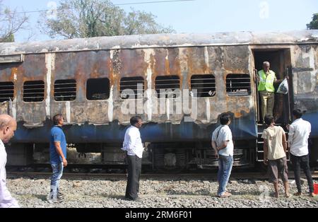 (140109) -- THANE, 8. Januar 2014 (Xinhua) -- Menschen versammeln sich bei einem verbrannten Bus des Mumbai-Dehradun Express, der am 8. Januar 2014 in Dahanu im Bezirk Thane in Maharashtra, Indien, Feuer fing. Neun Menschen, darunter eine Frau, wurden bei einem Großbrand, der auf dem Schnellzug im westindischen Bundesstaat Maharashtra in den frühen Morgenstunden des Mittwochs ausbrach, zu Tode gebrannt, sagte ein leitender Polizeibeamter. (Xinhua/Stringer) INDIA-MAHARASHTRA-EXPRESS TRAIN-FIRE PUBLICATIONxNOTxINxCHN 8. Januar 2014 XINHUA-Prominente treffen sich BEI einem verbrannten Bus von Mumbai Shipping, der im Bezirk Maharash Feuer fing Stockfoto